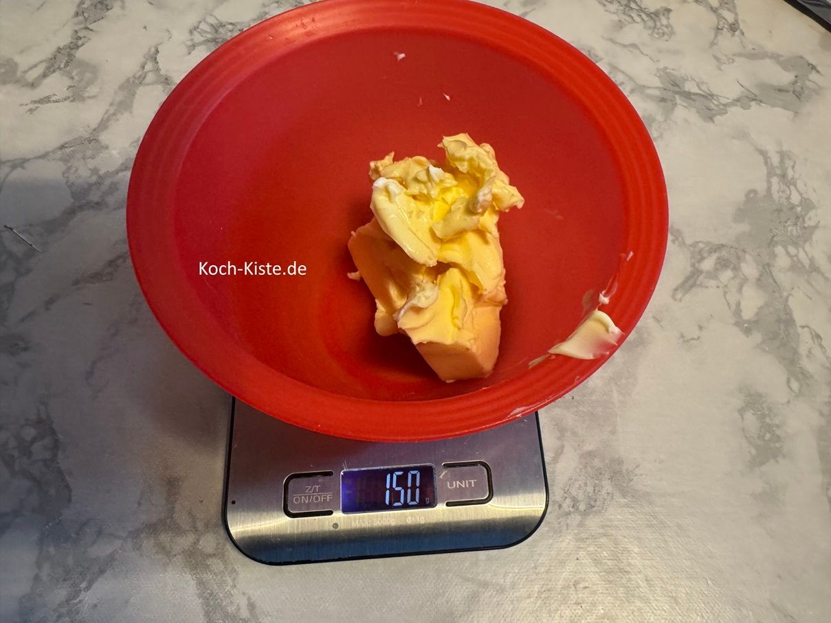 Jetzt fertige die Butter Zimt Mischung , dafür stelle die kleine Schüssel auf die Küchenwaage - auf 0 und schubse mit einem Messer 150 g weiche Butter hinein