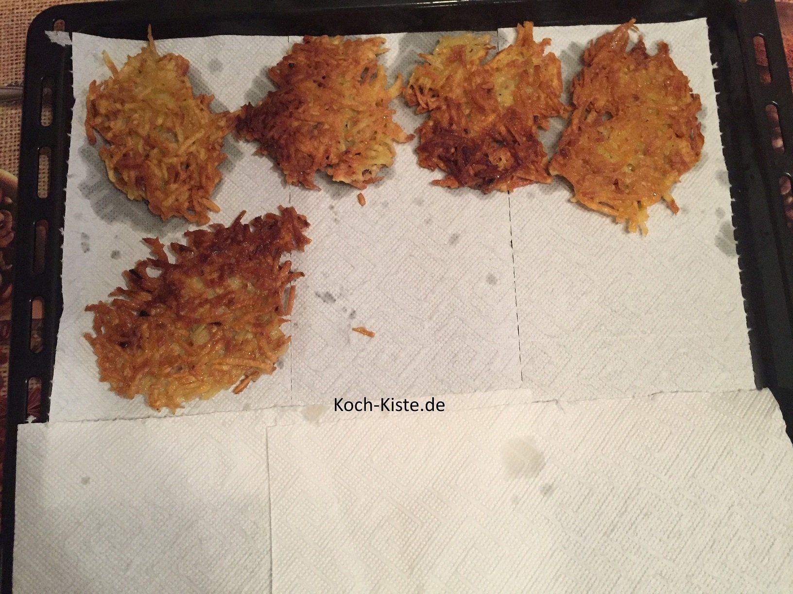 Backblech mit Küchenpapier auslegen und die Kartoffelpuffer darauf legen, damit das Fett ablaufen kann.