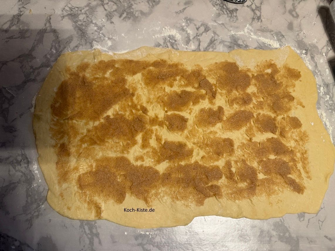 dann gebe mit den Tortenspatel 1 Ration Butter- Zimt Mischung auf den Teig. Lasse dabei am Rand ca. 2 cm frei