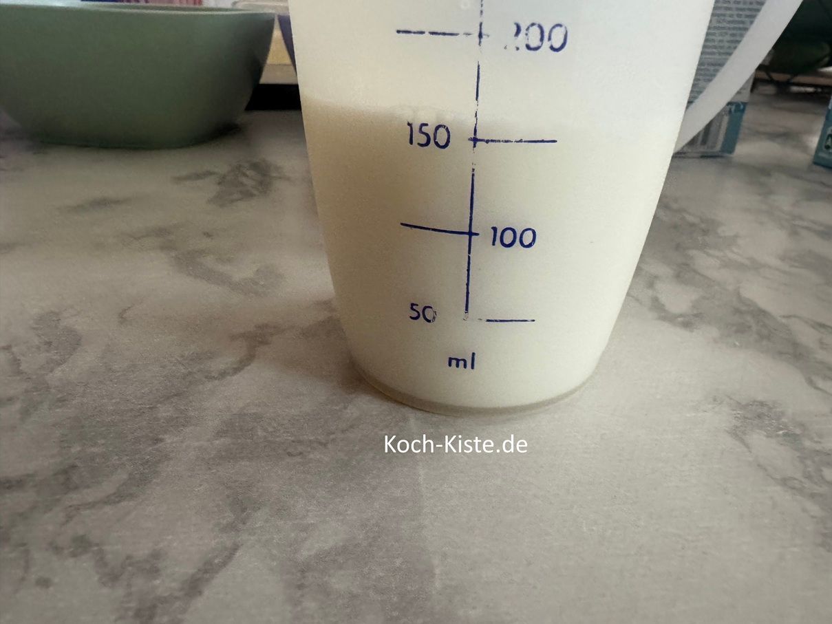 von den 750 Milliliter kommen 150 Milliliter Milch in einen kleinen Messbecher