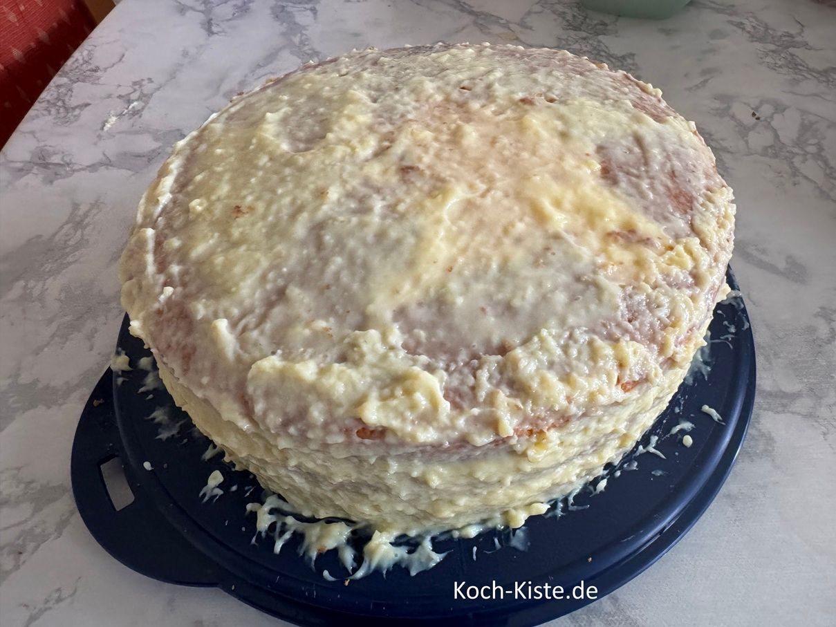 nehme den restlichen Vanillepudding. Gebe zuerst mit dem Tortenspatel den Pudding auf den seitlichen Rand der Torte an. Danach verteile den Restpudding auf der Tortenboden Oberfläache.