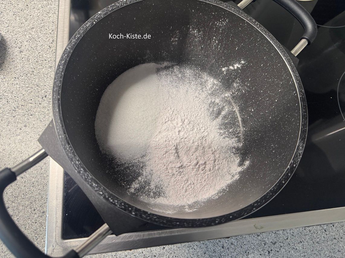 jetzt kommt der Tortenguss dran - gebe 4 Esslöffel Zucker und 2 Päckchen Erdbeertortenguss in den Topf