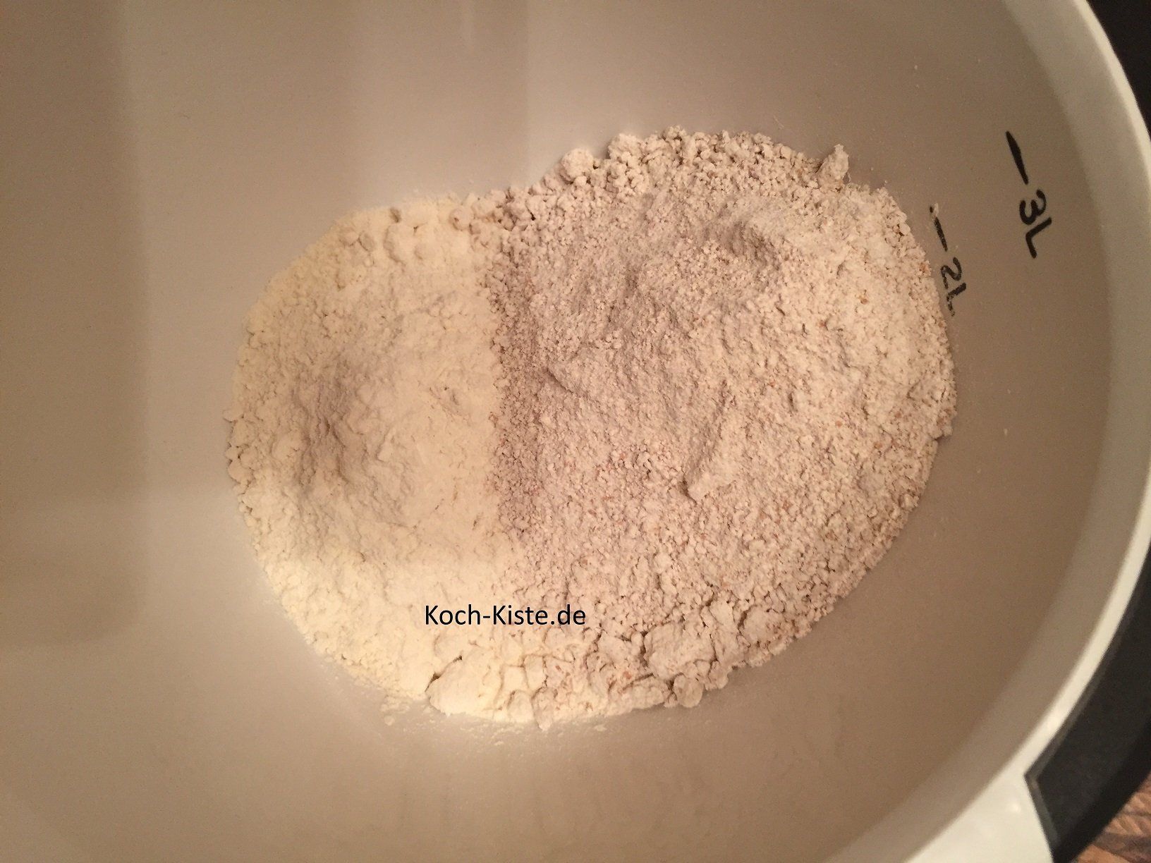 Dinkelweizenmehl und Weizenmehl in eine Rührschüssel geben