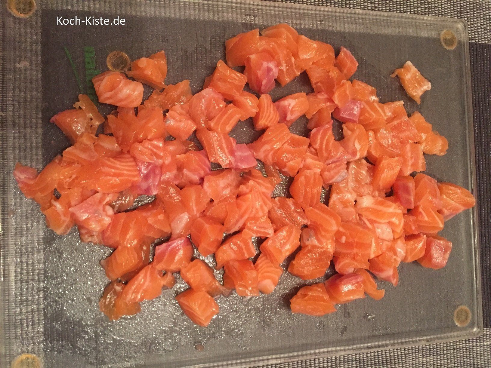 Lachsfilet abspülen, trocken tupfen und in kleine Würfel schneiden