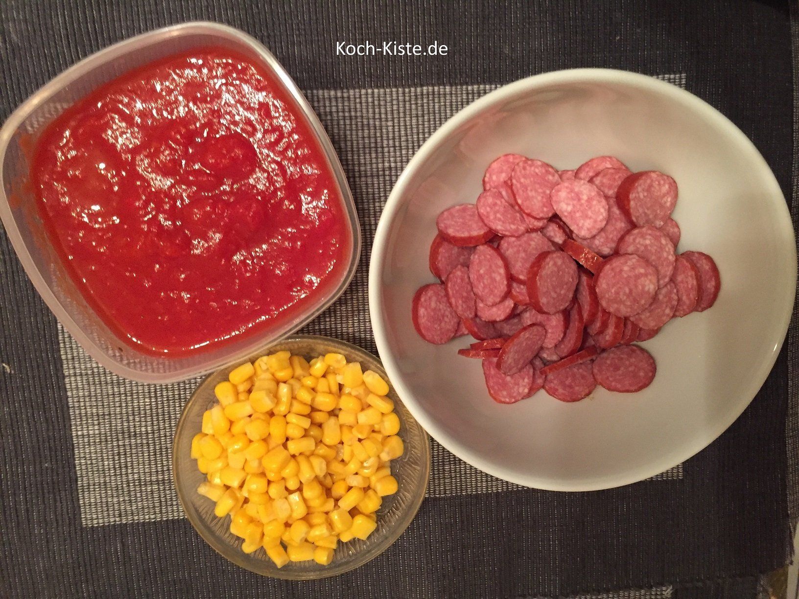 Kabanossi in Scheiben schneiden, Mais Dose öffnen und gehackte Tomatenpackung öffnen