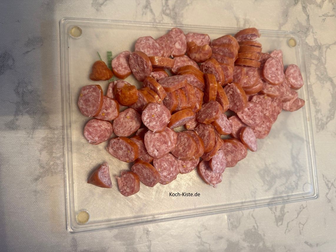 dann schneide die Mettenden in Scheiben und gebe die Mettendenscheiben in eine Schüssel