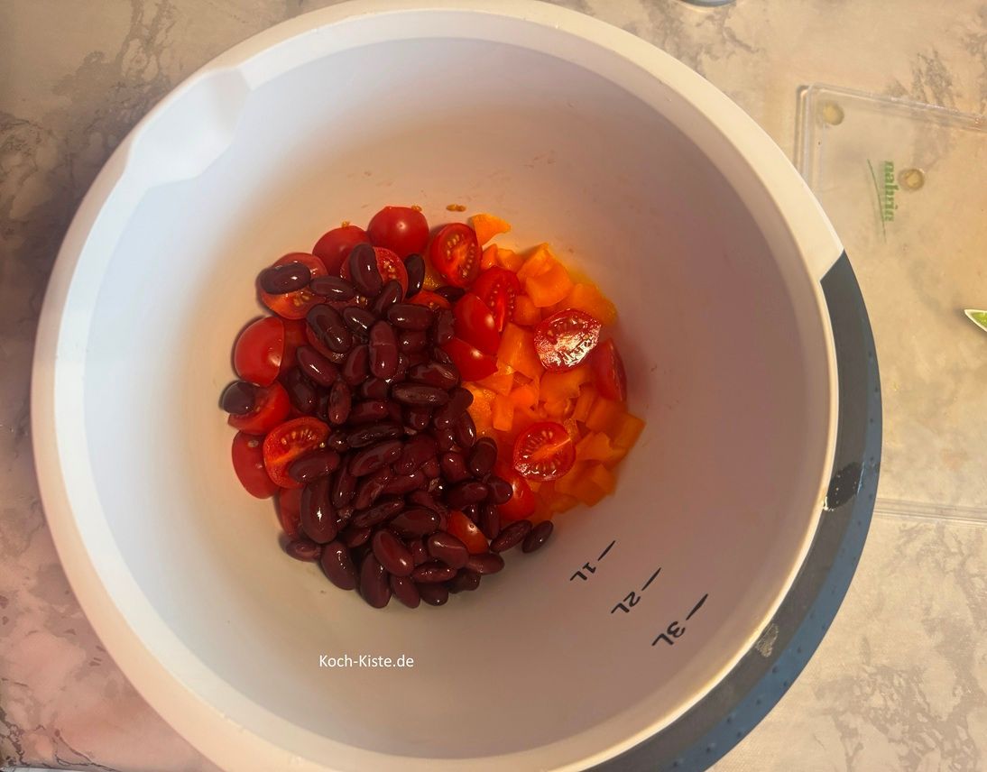 stelle ein kleines Küchensieb in die Spüle, öffne die Kidneybohnendose und kippe den Inhalt in das Küchensieb. Nun spüle die Kidneybohnen mit kaltem , fließendem Wasser ab. Zum Schluss gebe die Kidneybohnen mit in die Rührschüssel.