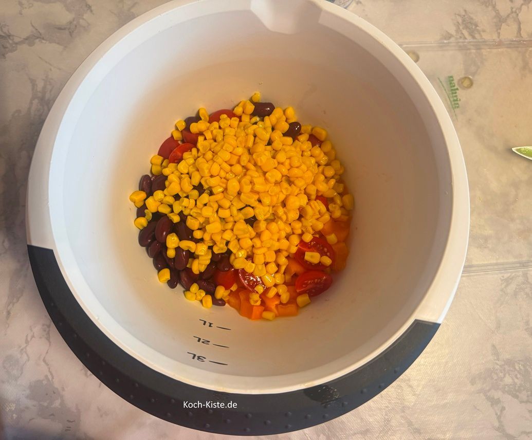 Öffne die Maisdose, lasse die Flüssigkeit über der Süle abtropfen und gebe den Mais mit in die Rührschüssel.
