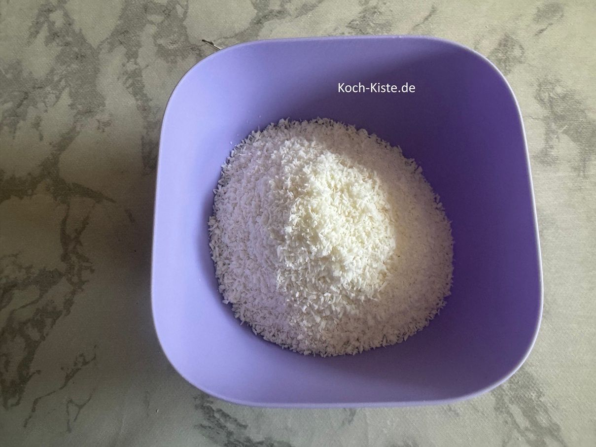 für den Belag stelle eine Schale auf die Küchenwaage - auf 0 und wiege 75 g Kokosraspel hinein