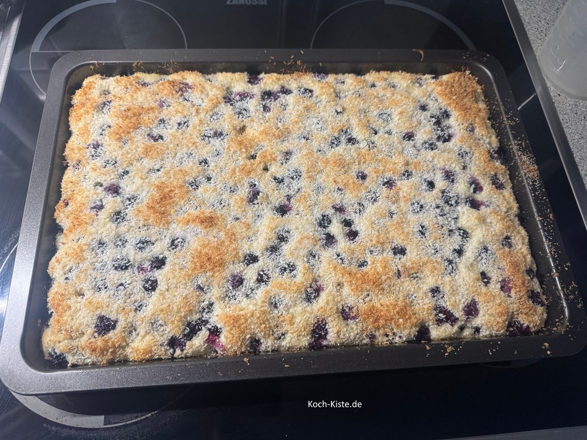 schiebe das Backblech in die mittlere Schiene des Backofens und backe den Blaubeer Kokos Kuchen für 20 b25 Minuten