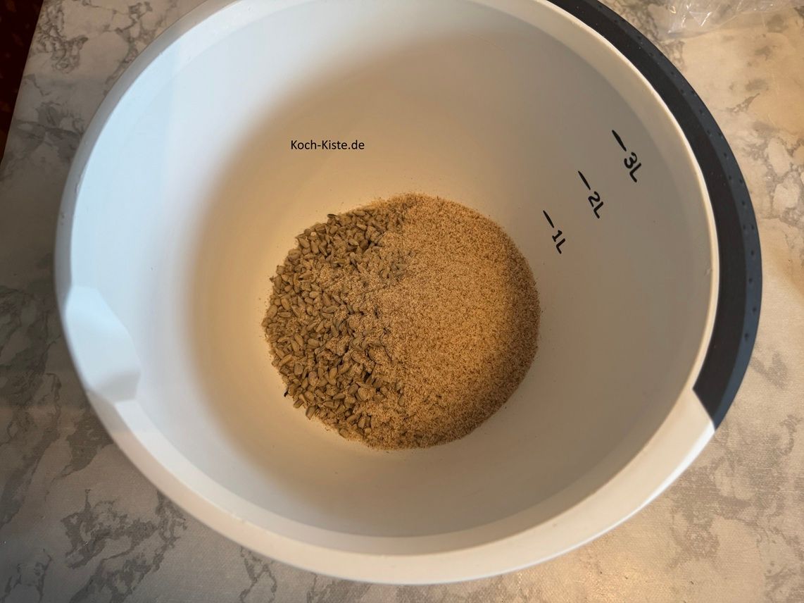 stelle eine Rührschüssel auf die Küchenwaage - auf 0 und wiege 135g Sonnenblumenkerne ab. Stelle die Küchenwaage wieder auf 0 dann wiege 20 g Flohsamenschalen ab