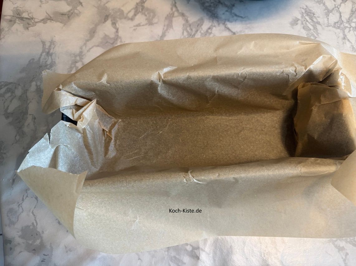 Als nächstes nehme Dir 1 Bogen Backpapier und lege ihn in die Kastenform - so das diese mit dem Backpapier bedeckt ist.