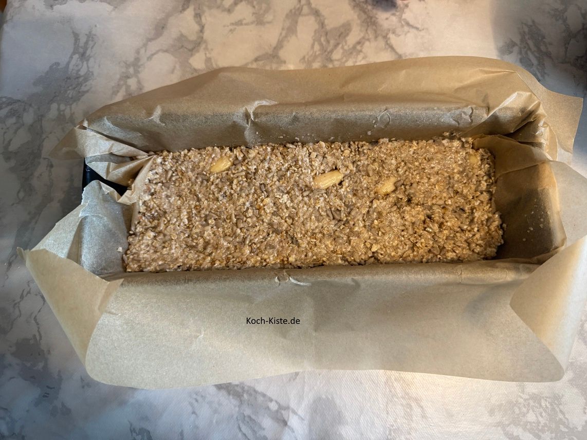 Dann fülle mit dem Esslöffel den Teig in die Kastenform und streiche mit der Esslöffelrückseite die Oberfläche glatt-