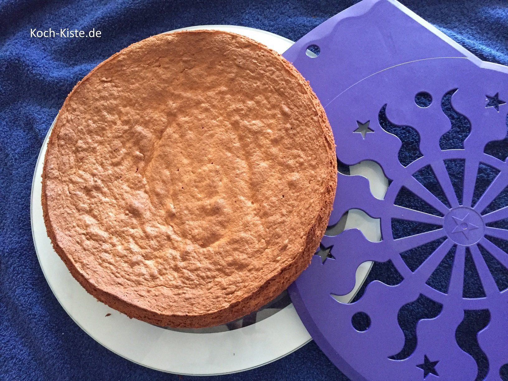 Möhrenkuchen mit Hilfe eines Tortenhebebleches auf die Tortenplatte heben