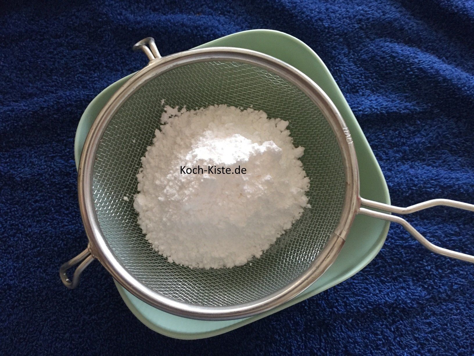 Puderzucker durch ein Sieb streichen