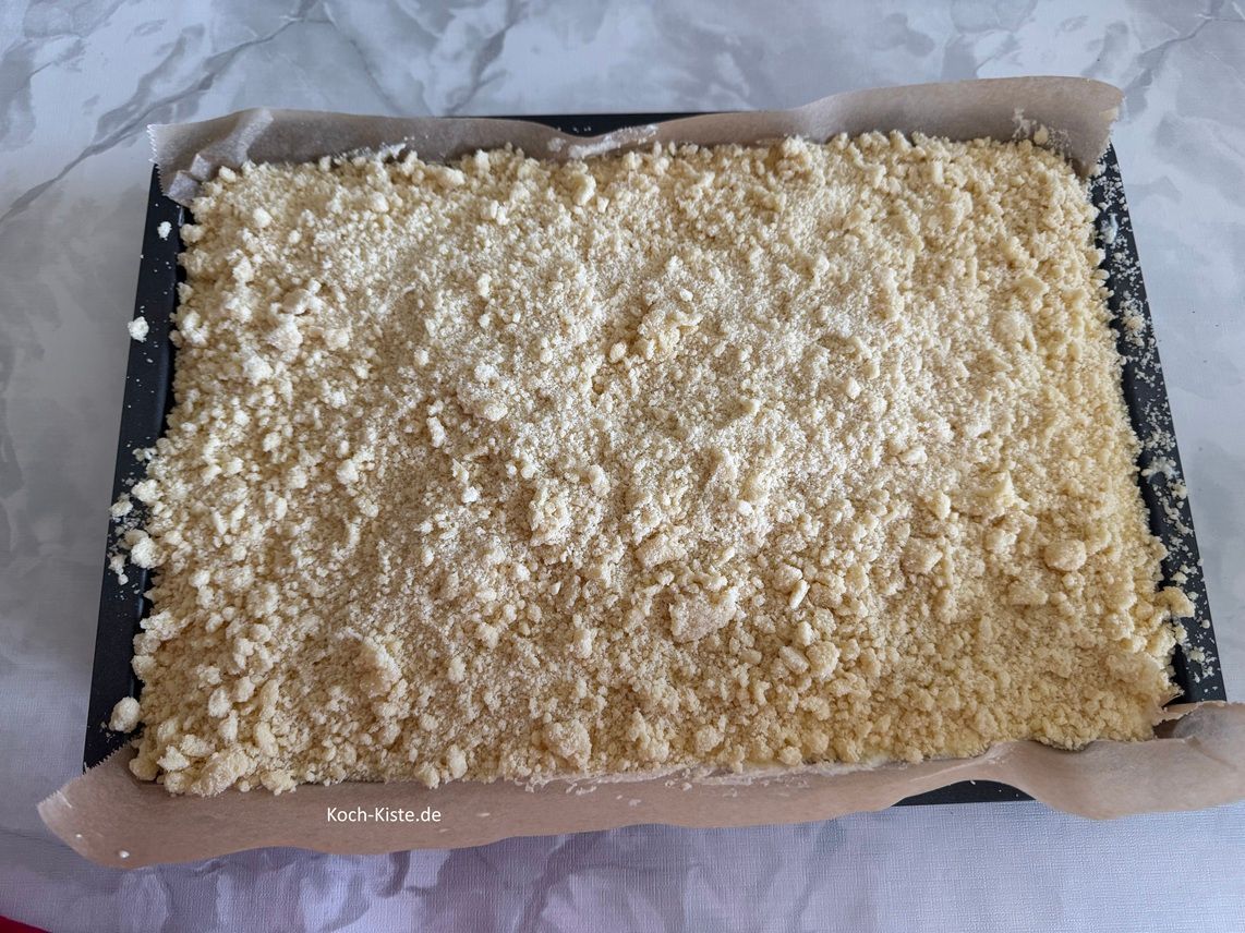 zum Schluss verteile die Streusel gleichmäßig über den Käsekuchen