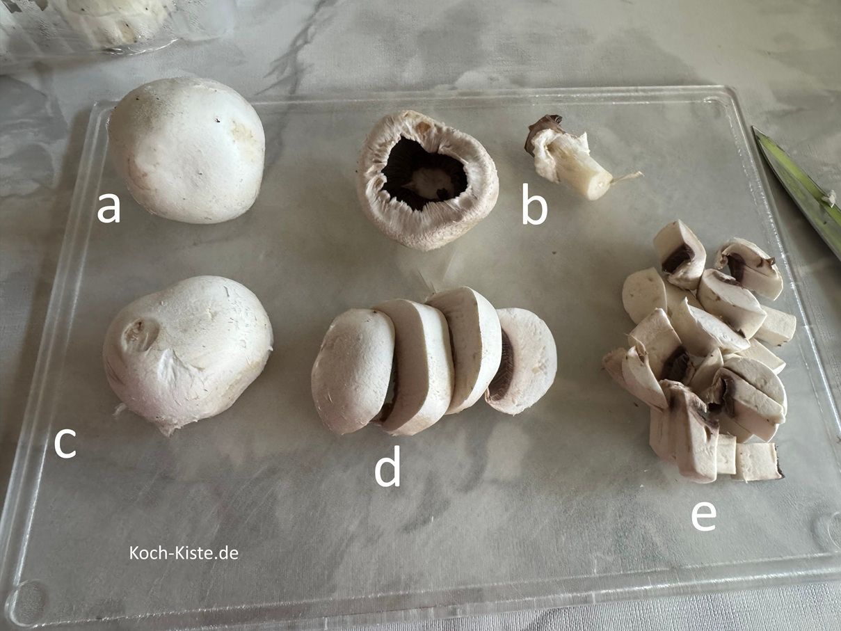 beginne damit beim Champi, mit einem Küchenpapier eventuell vorhandende Erdreste abzuwischen. Dann lege den Champi auf das Schneidebrett (a), entferne den Pilzfuß (b), drehe den Champi um (c), schneide ihn in Scheiben(d) und dann in kleine Stücke (e).