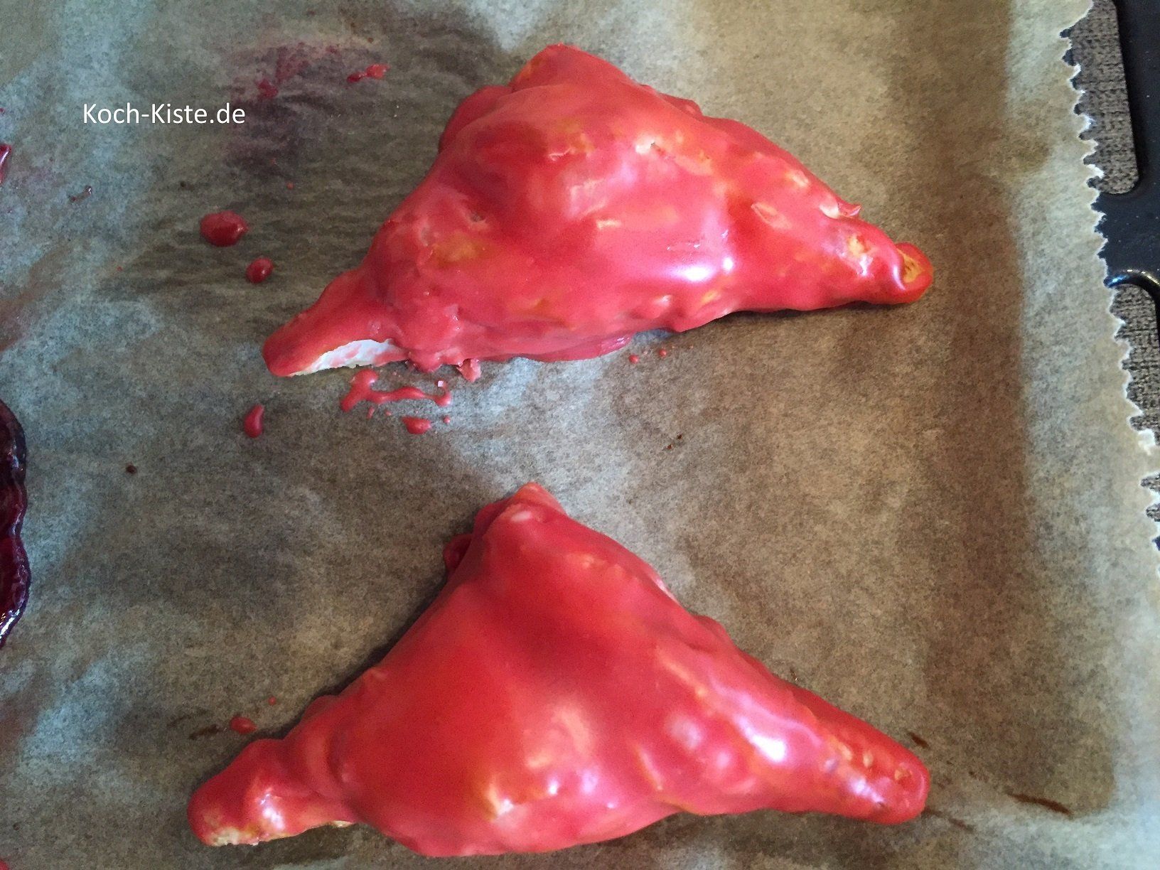 die Marmeladen-Kopenhagener mit dem roten Zuckergus bestreichen.