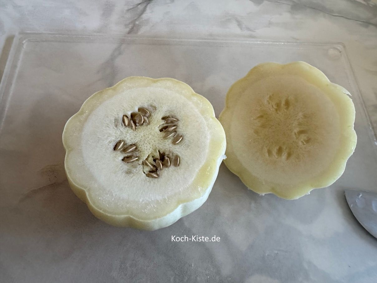 lege einen Casperita Kürbis auf das Schneidebrett und schneide einen Deckel ab. Dieser sollte knapp 1/3 der Kürbismasse betragen.