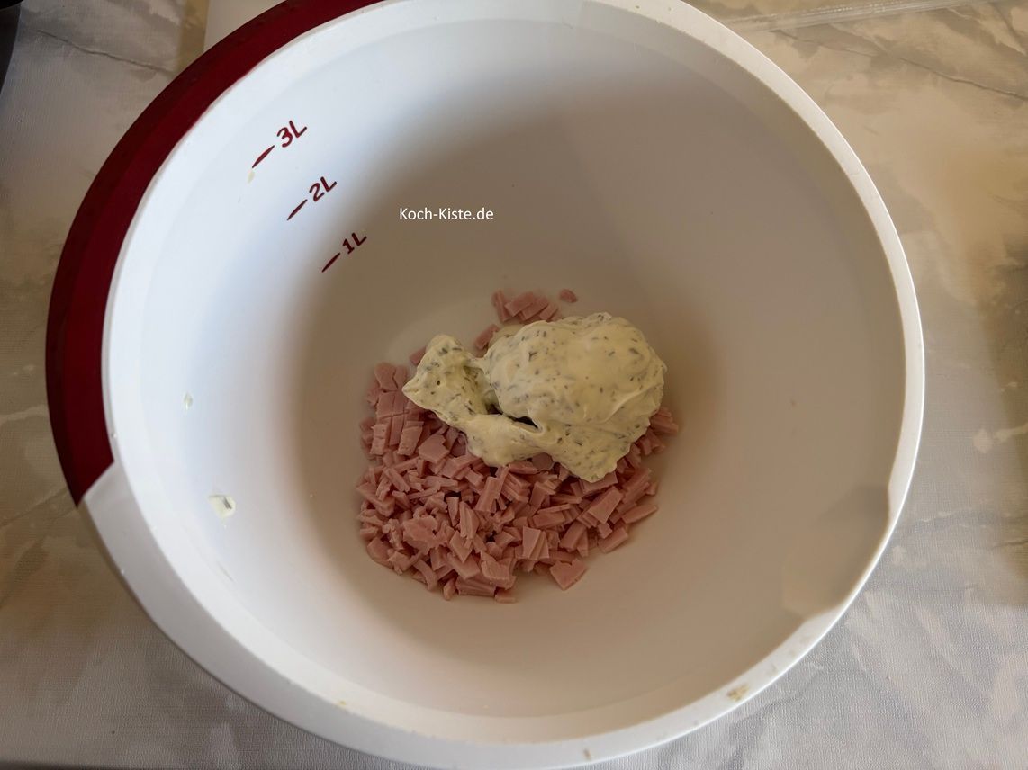 gebe in die Rührschüssel mit dem gekochten Schinken 200 g Creme fraiche.