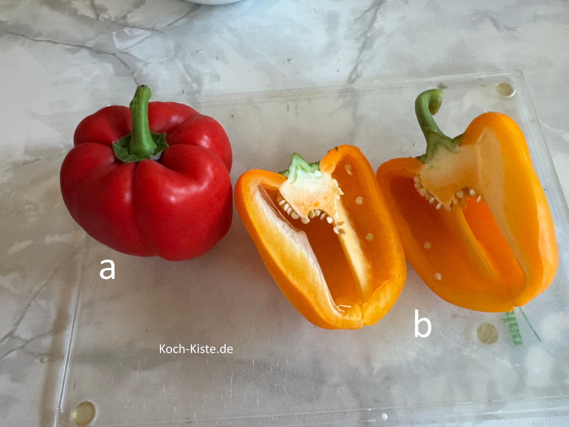 beginne damit die Paprika auf das Schneidebrett zu legen (a) und zu halbieren (b)