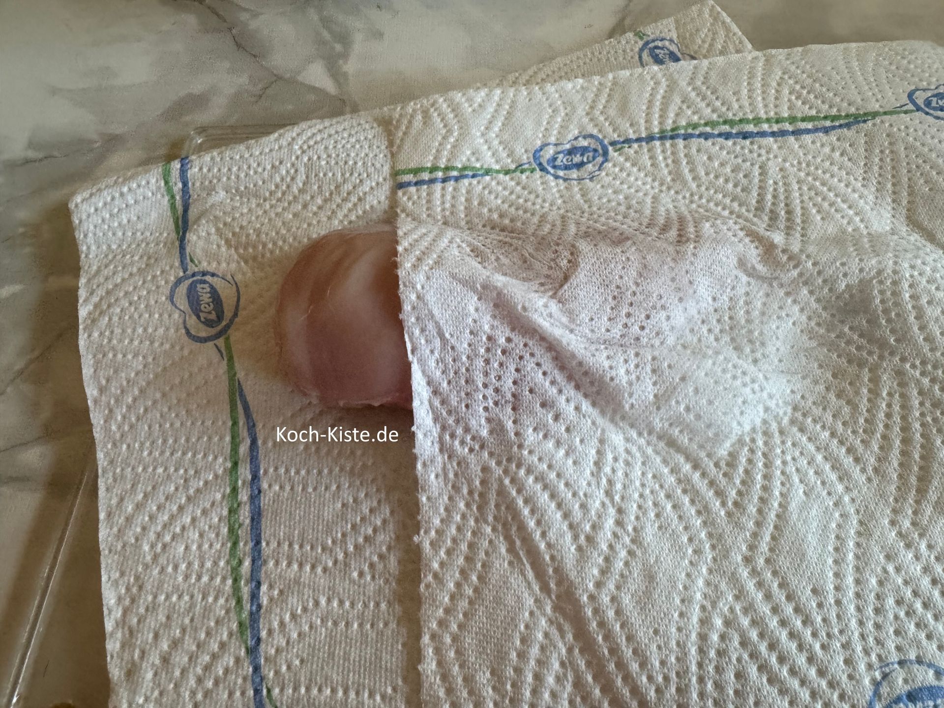 als nächstes lege 1 Küchenpapier auf das Schneidebrett, darauf 1 Hähnchenbrustfilet und darauf wieder 1 Küchenpapier. Nun kannst Du das Felsichstück trocken tupfen.