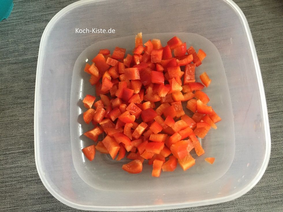 Paprika halbieren, Strunk entfernen, vierteln, Innenhäute entfernen, unter kaltem, fließendem Wasser abspülen und in kleine Stücke schneiden