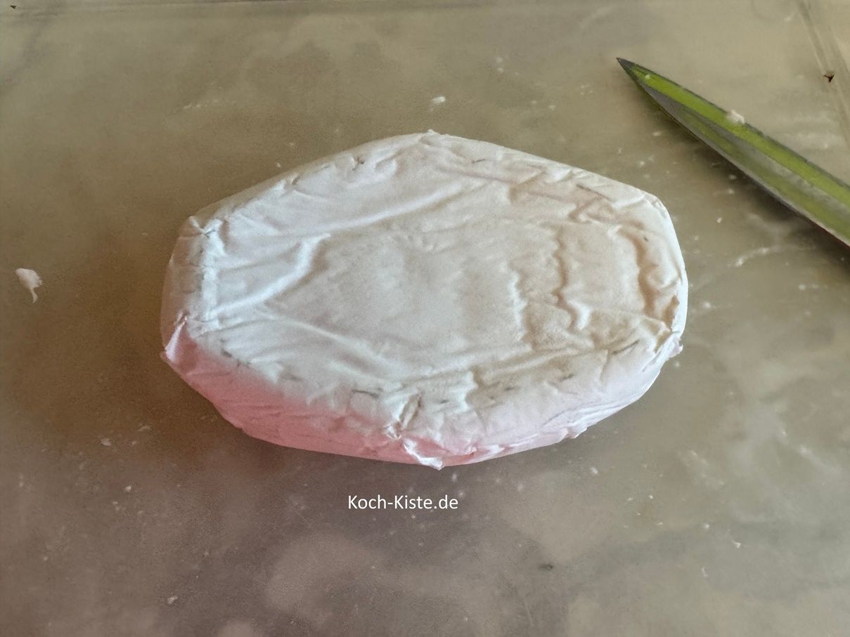 lege den Camembert auf das Schneidebrett