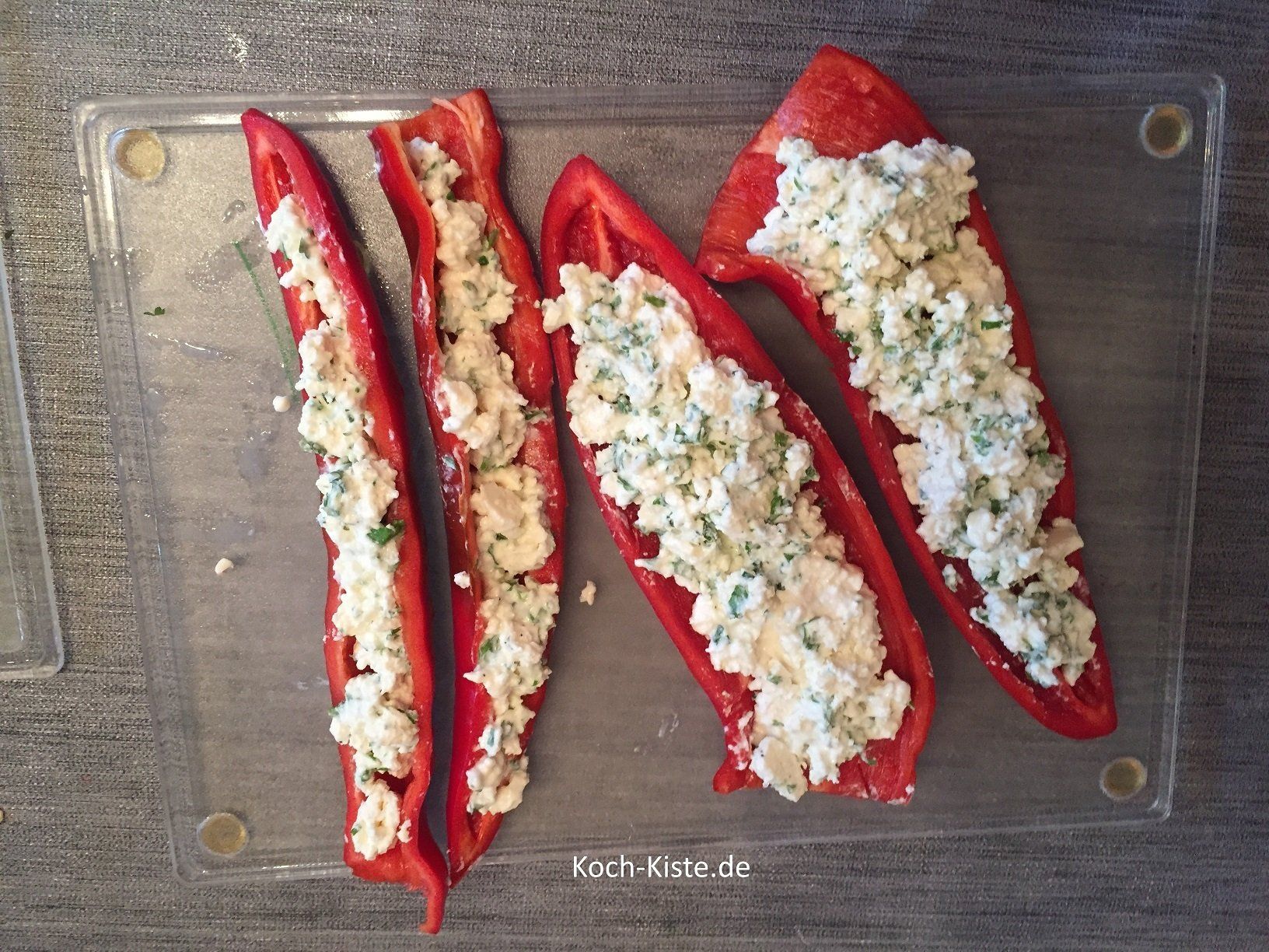 die Spitzpaprika mit der Käsemischung füllen und dann in die Grillpfannen setzen