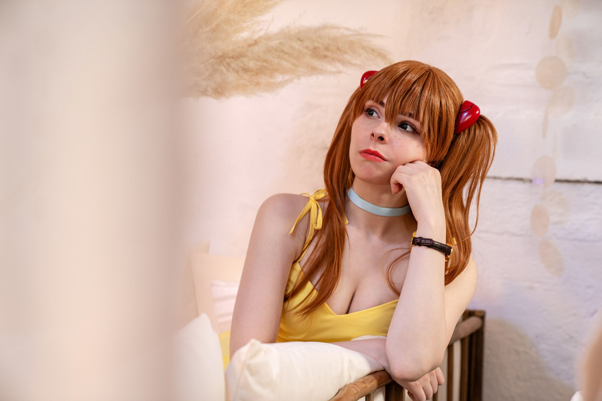 Cosplayerin stützt das Kinn auf die Hand und schaut in die Kamera