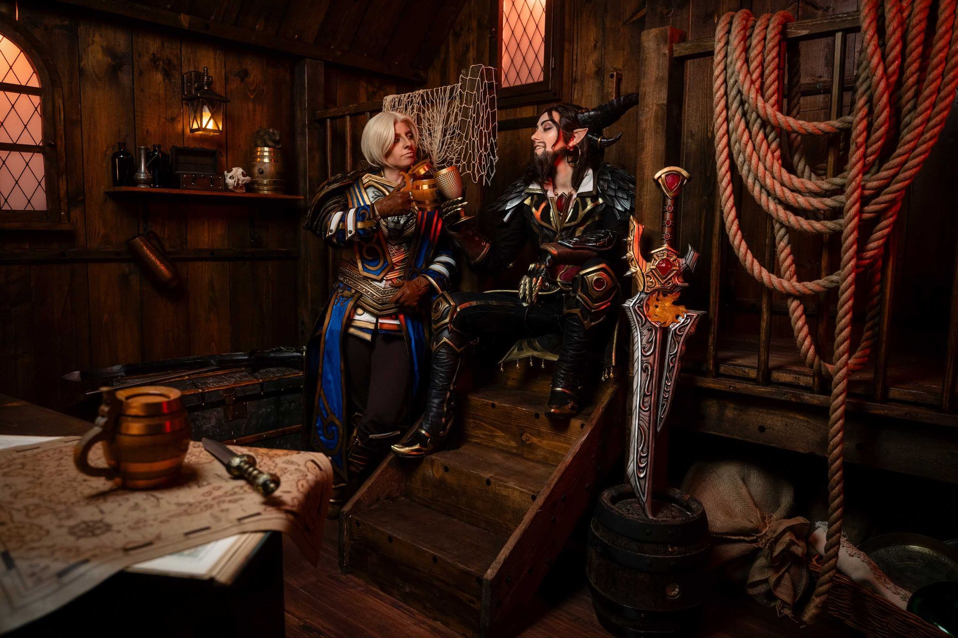Zwei World-of-Warcraft-Charaktere sitzen an einem Tisch in einer Taverne