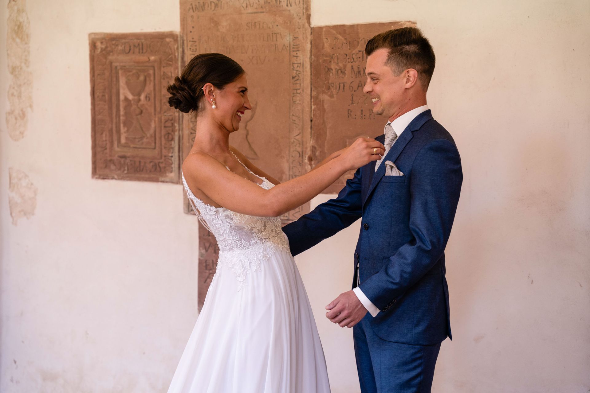 First Look im Kreuzgang Kloster Bronnbach, Braut ist beim Bräutigam und er will sie umarmen.