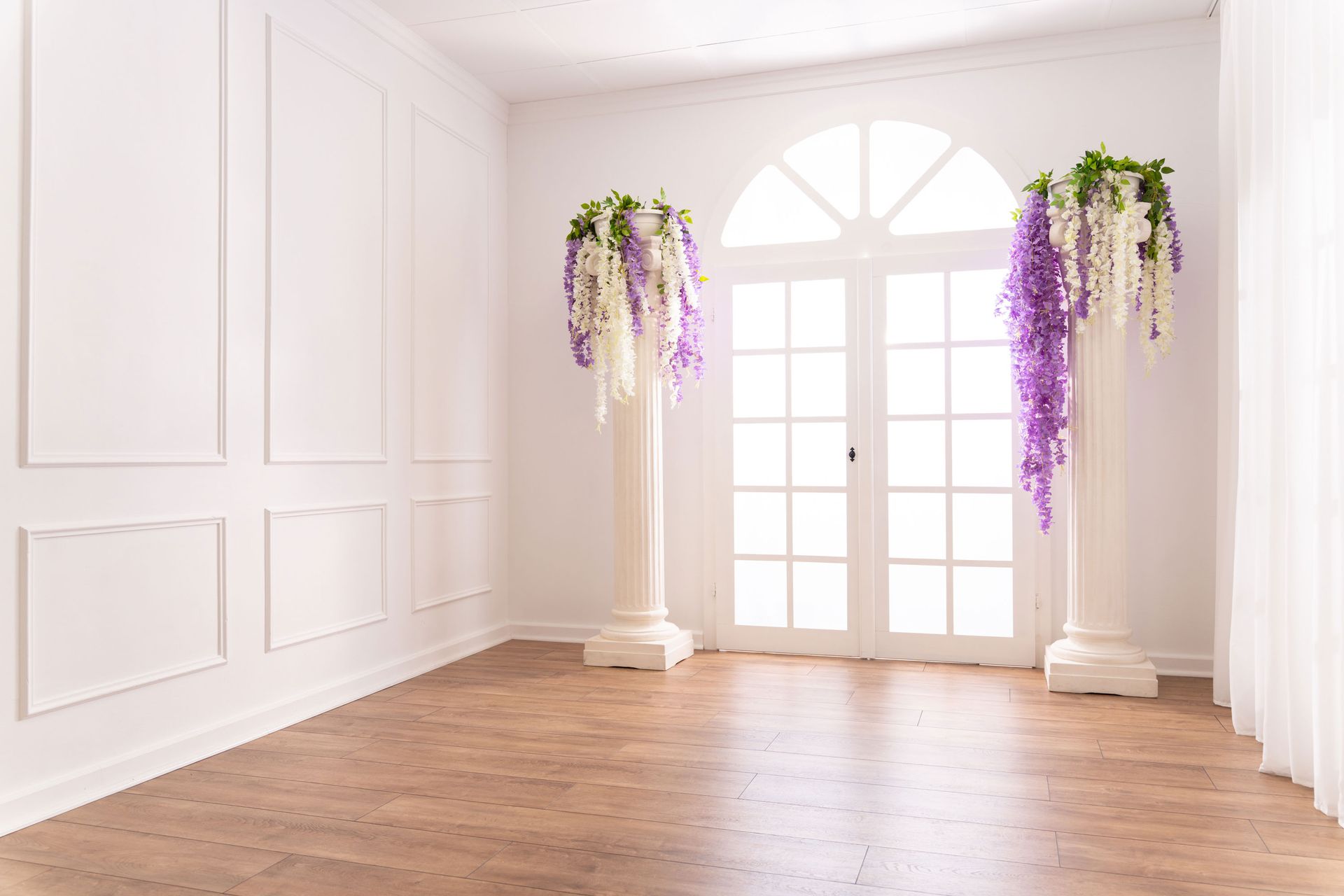 Mietstudio weißer Raum Studio zum mieten für Cosplay Fotografie. Säulen mit Blumen am großen weißen Fenster bei Barockwand.