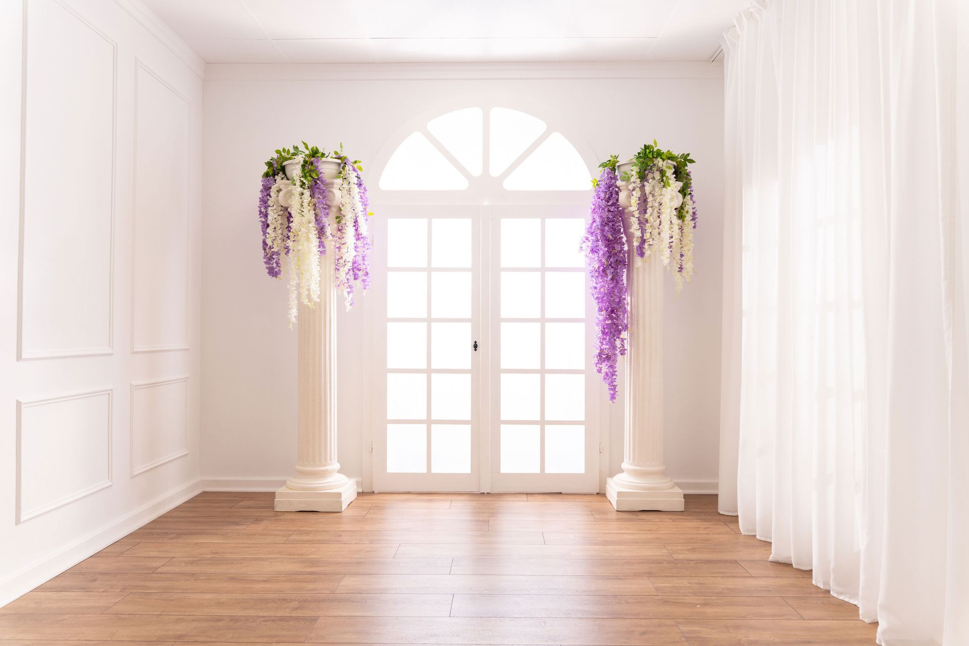 Mietstudio weißer Raum Studio zum mieten für Cosplay Fotografie. Säulen mit Blumen am großen weißen Fenster.