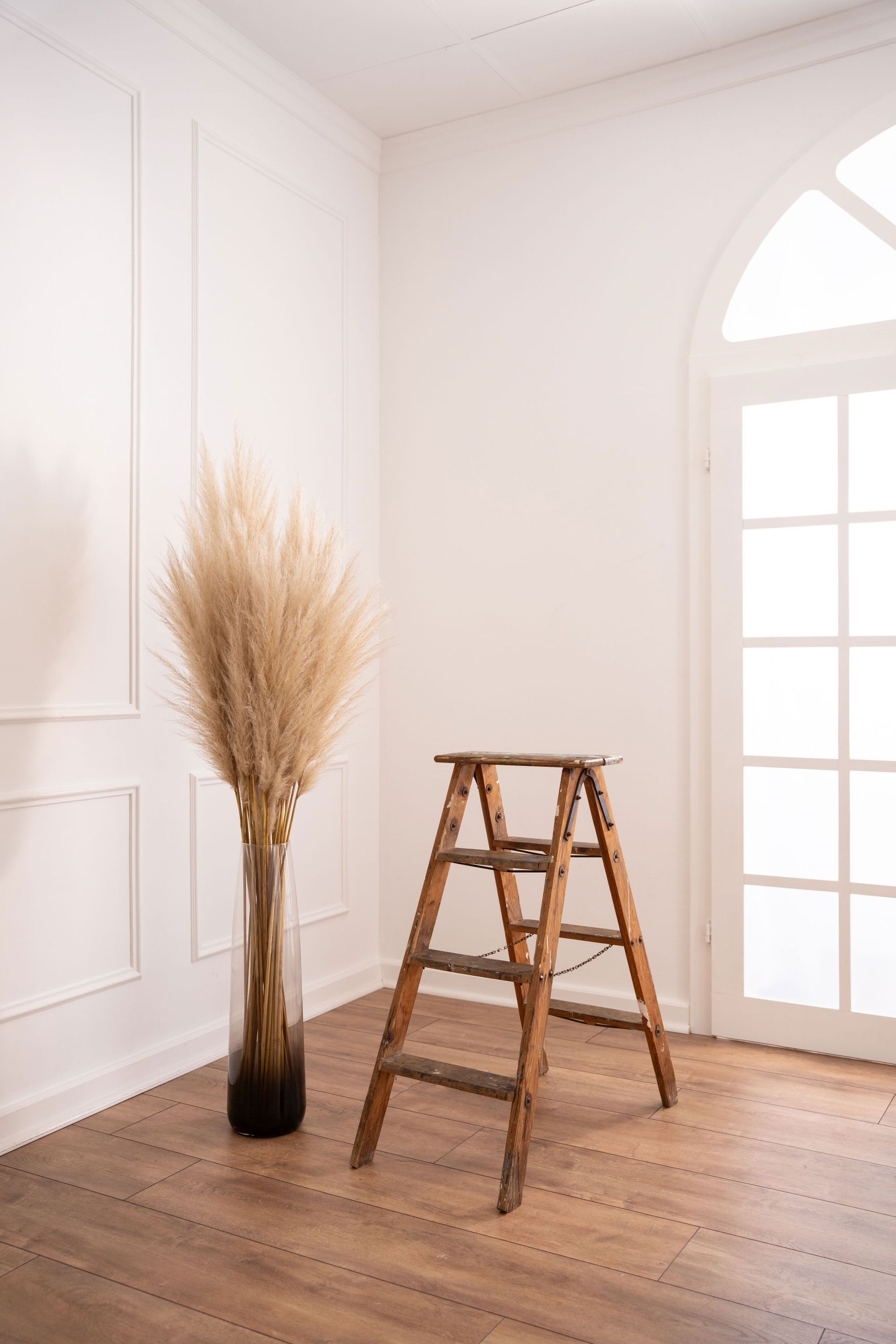 Weißer Raum mit weißer Säule und dekorativer Blumenvase – ruhige und ästhetische Shooting-Location.