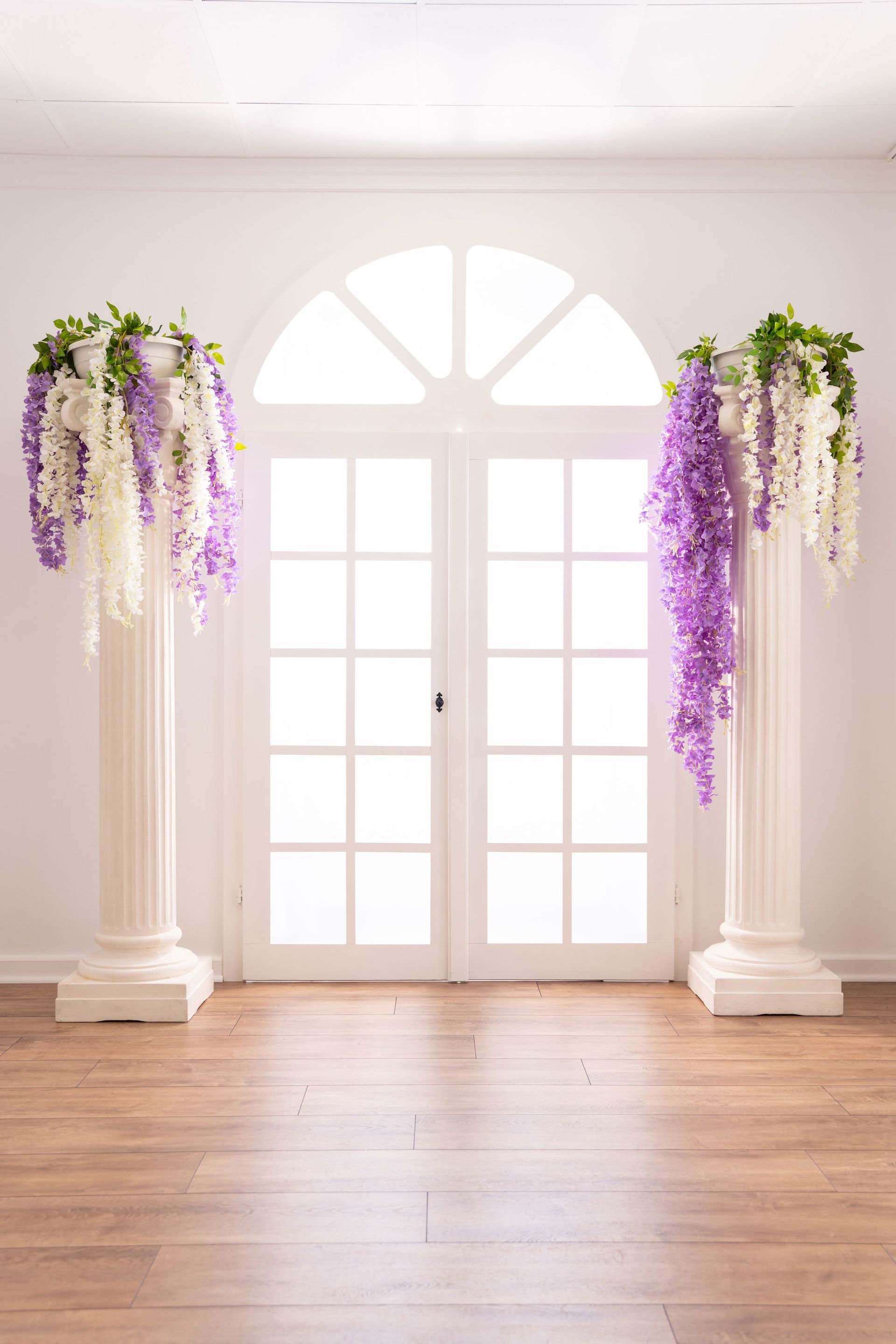 Mietstudio weißer Raum Studio zum mieten für Cosplay Fotografie. Säulen mit Blumen am großen weißen Fenster.