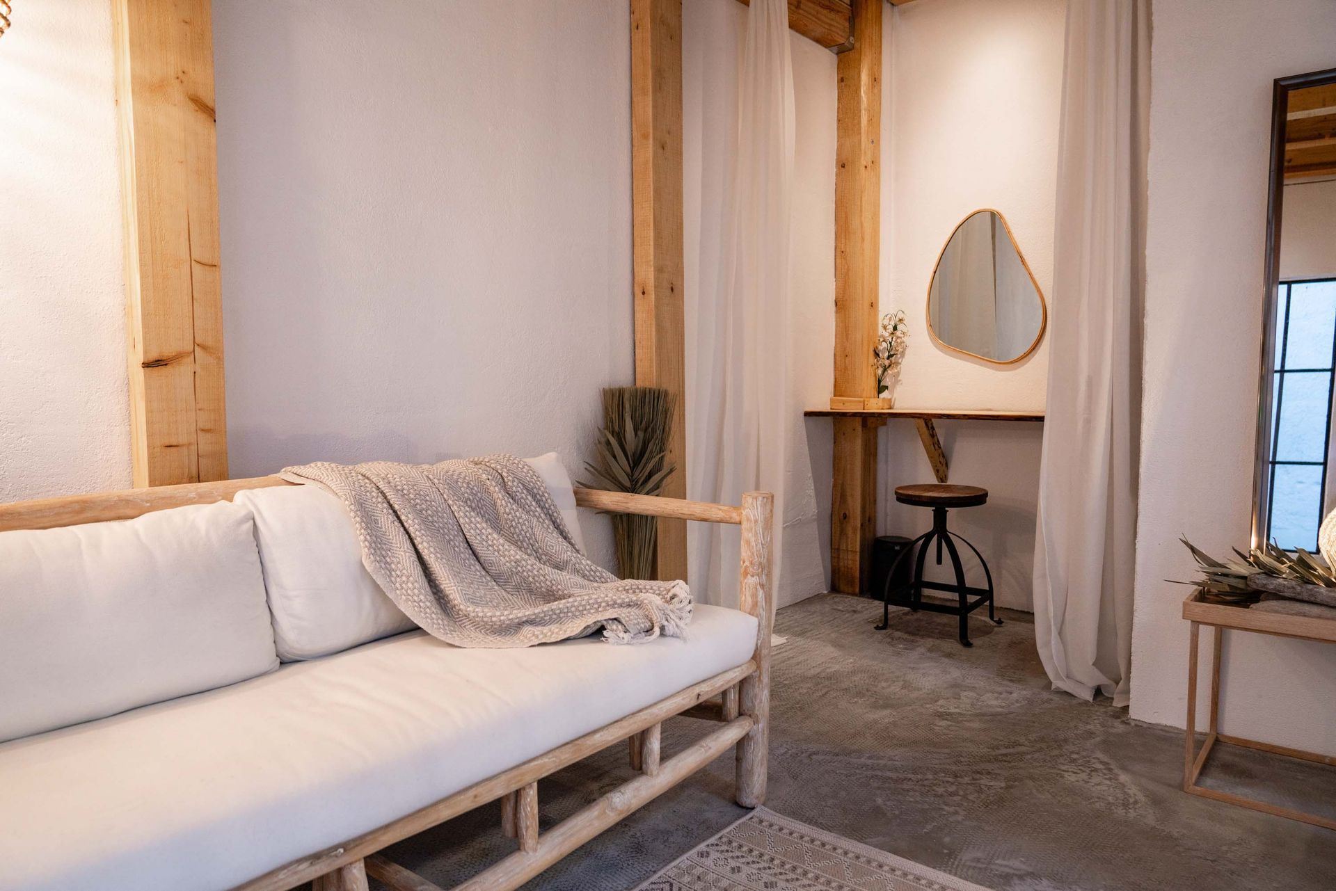 Heller Sitzbereich mit weißem Sofa und Holzelementen