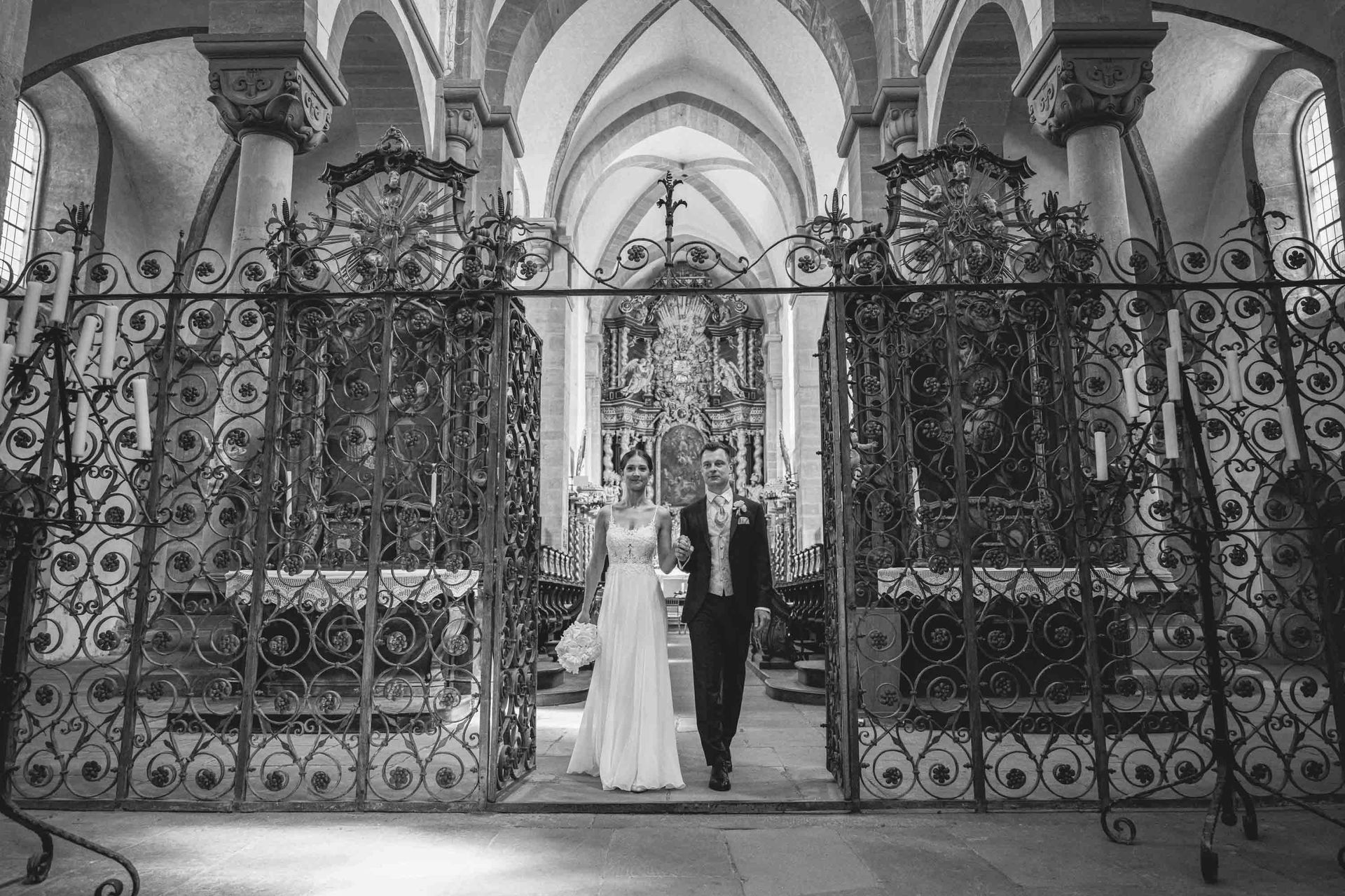 Schwarz-weiß Foto. Klosterkirche im Kloster Bronnbach kirchliche Trauung, Brautpaar beim Auszug aus der Kirche.