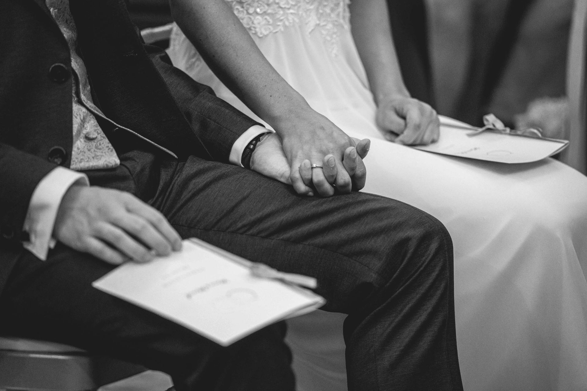 Schwarz-weiß Foto Klosterkirche im Kloster Bronnbach kirchliche Trauung, Deteilsfoto auch Brautpaar das Händchen hält.