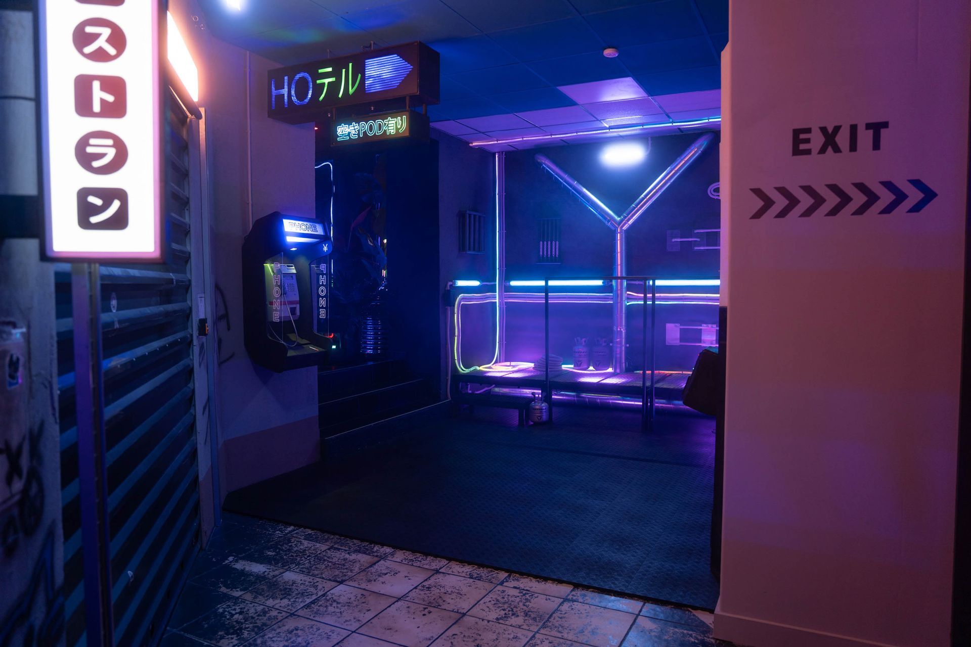 Neonbeleuchteter Gang mit „EXIT“-Schild und blauer Beleuchtung