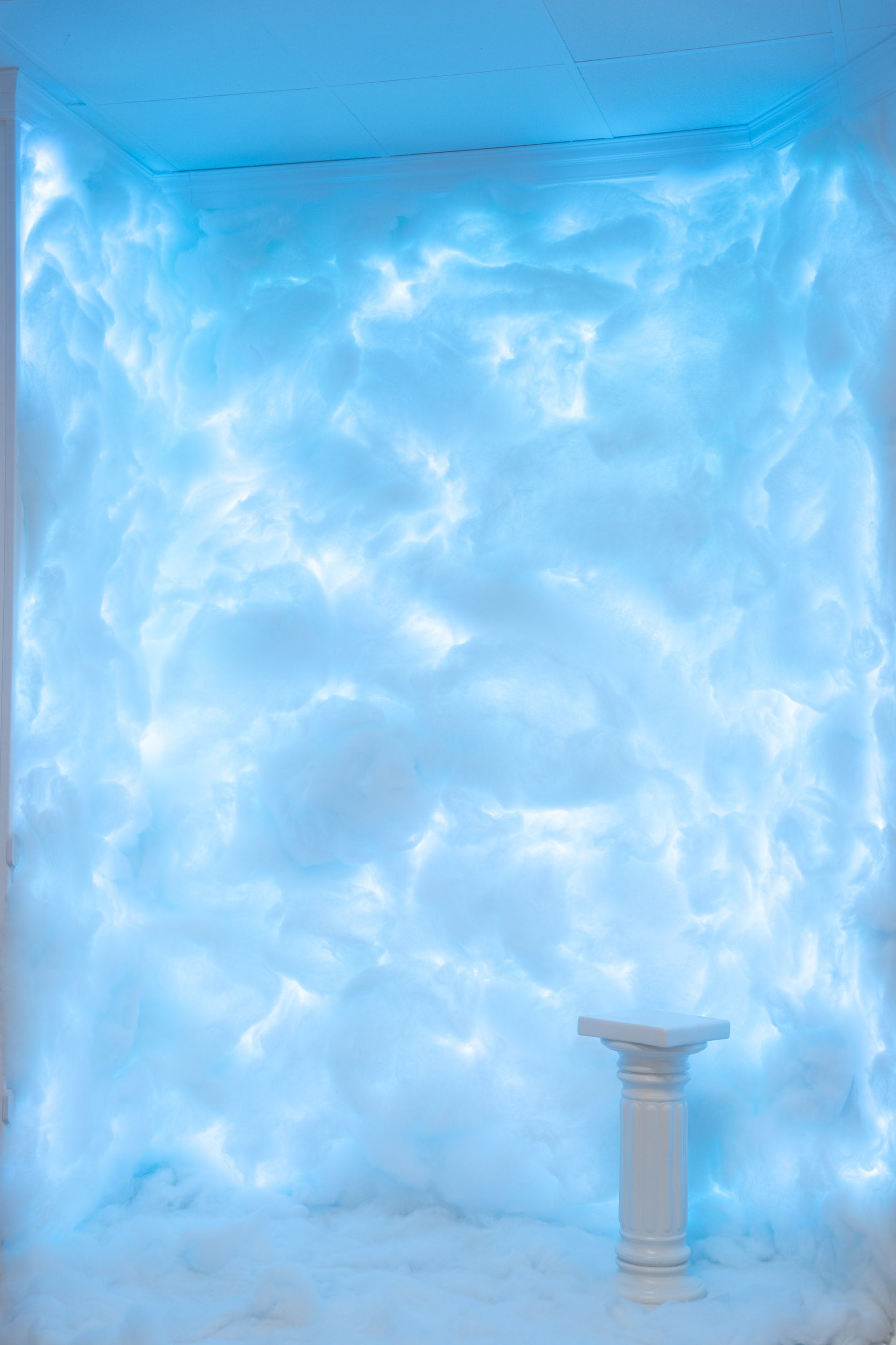 Heller blauer Raum mit Säulen und Wolkenprojektion – kühle und träumerische Lichtstimmung für atmosphärische Shootings.