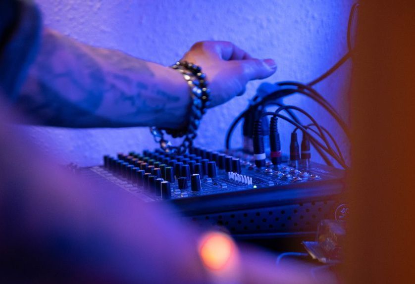 Gros plan sur la main de l'animateur DJ se trouvant au dessus de la régie son