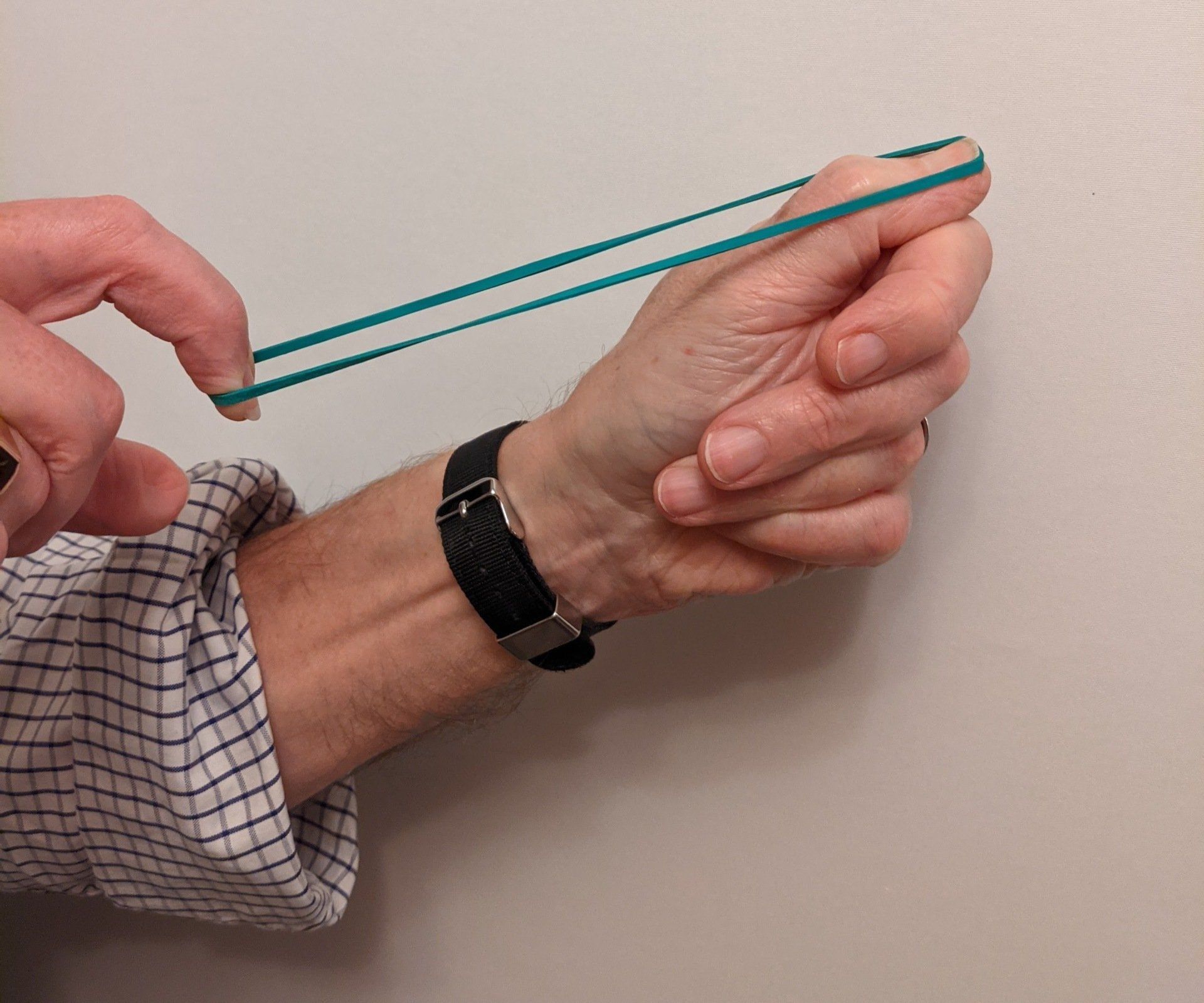 Hands holding an elastic band that is about to be flicked