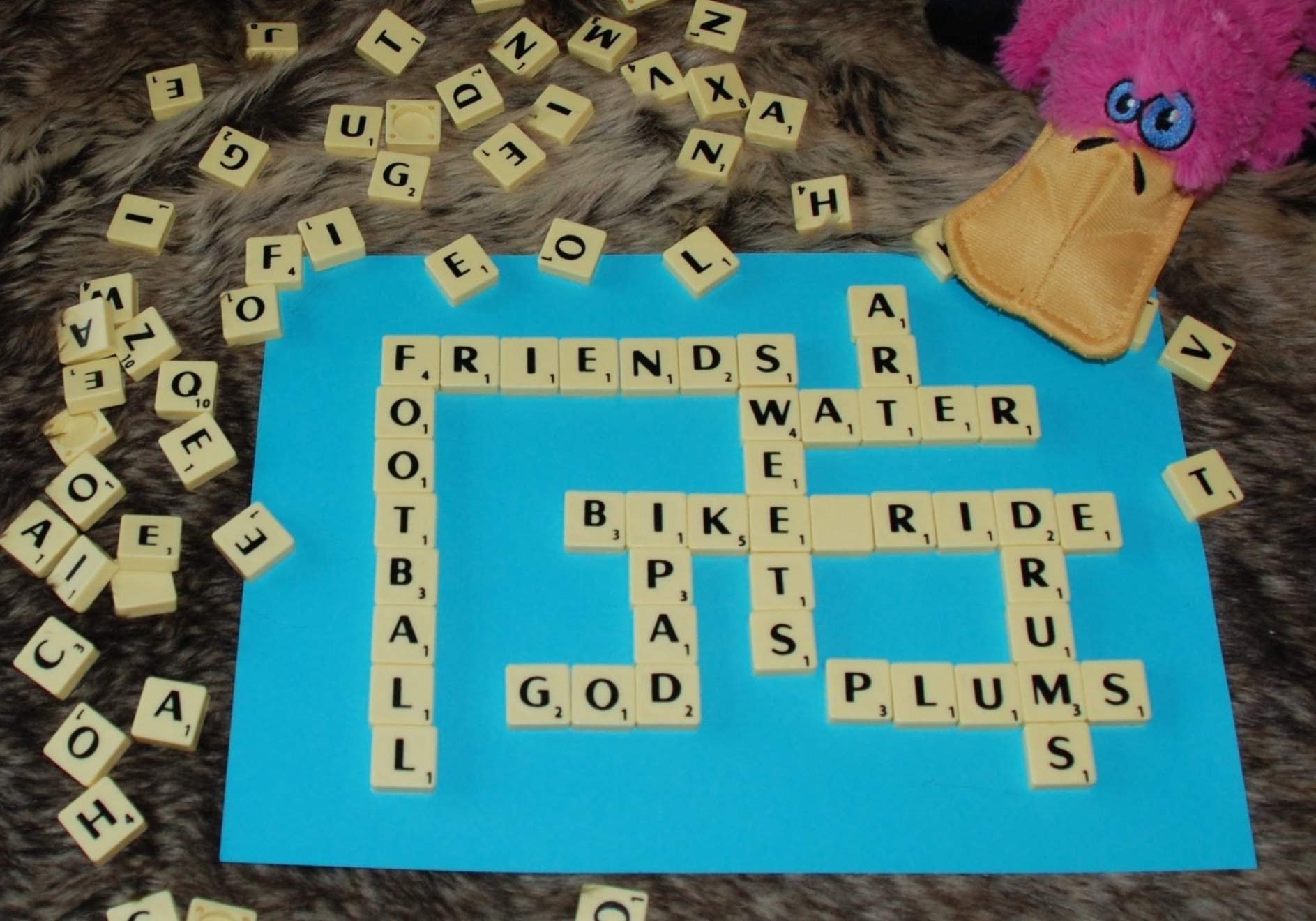 A blue board with a scrabble game using  names of things we are thankful for. Anno the small pink Platypus can just be seen in the top right hand corner