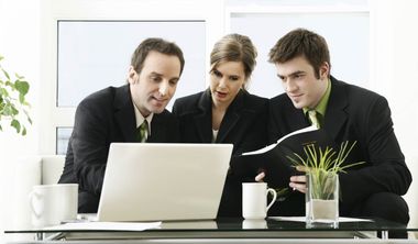 3 Arbeitnehmer schauen auf einen Laptop