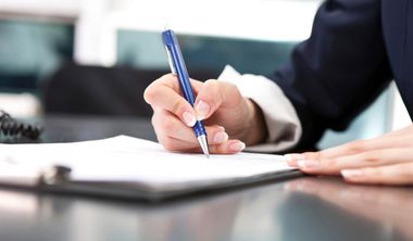 Frau unterschreibt Arbeitsvertrag mit blauem Stift