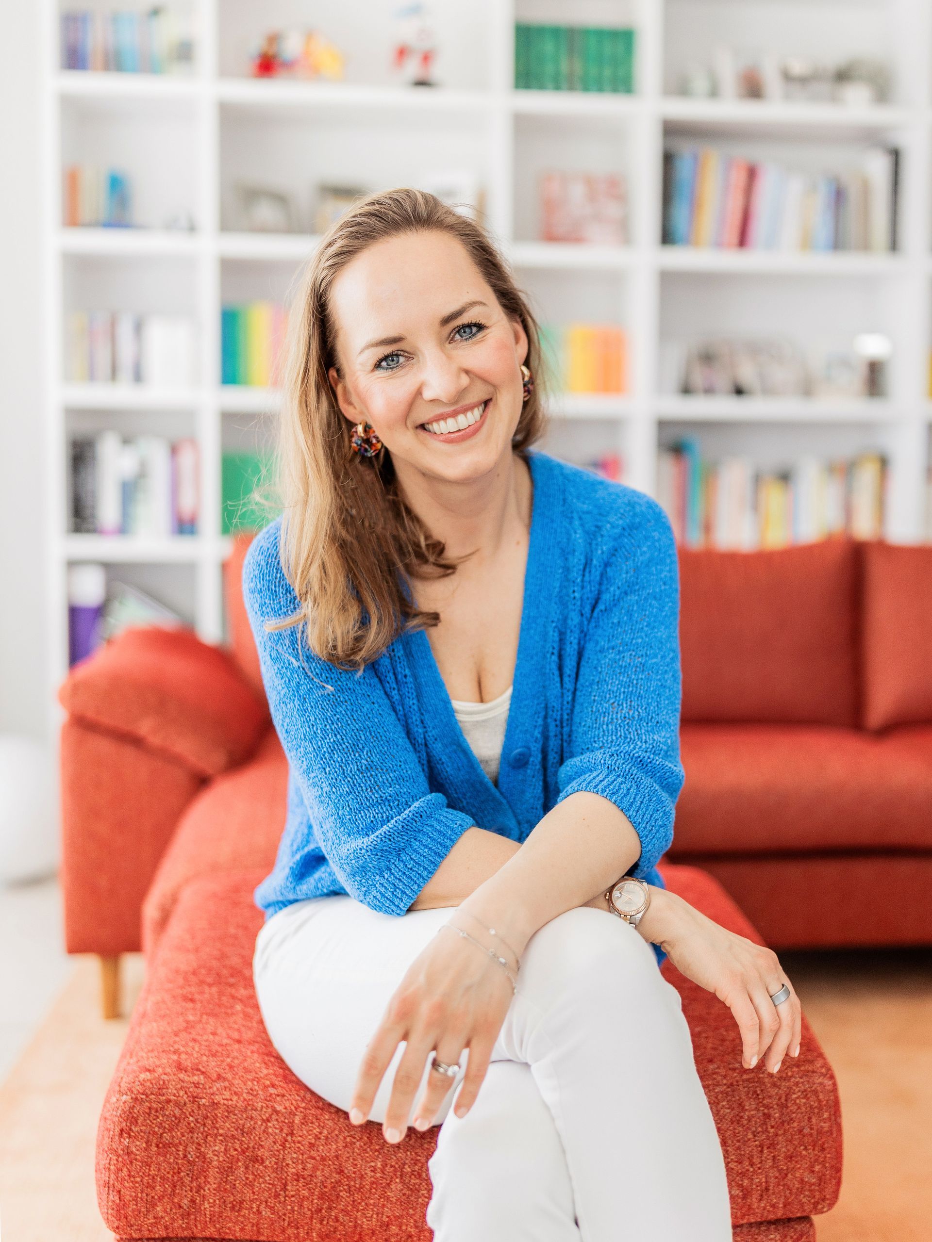 Smiling woman sitting on couch representing holistic lifestyle coaching support