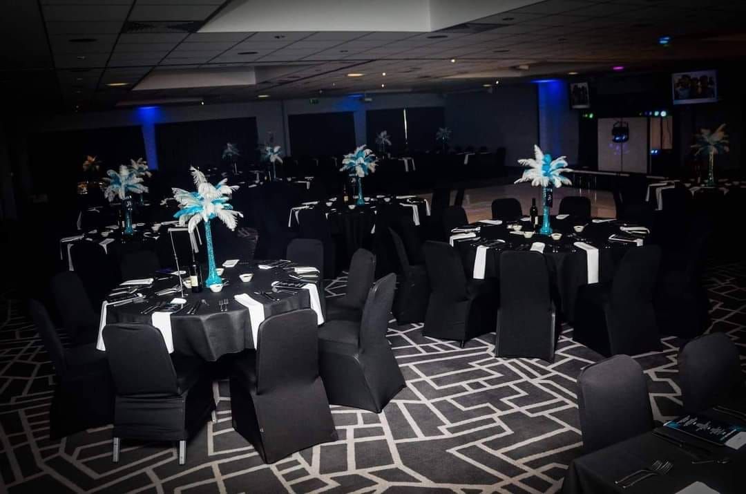 Feather centrepieces on black table cloths