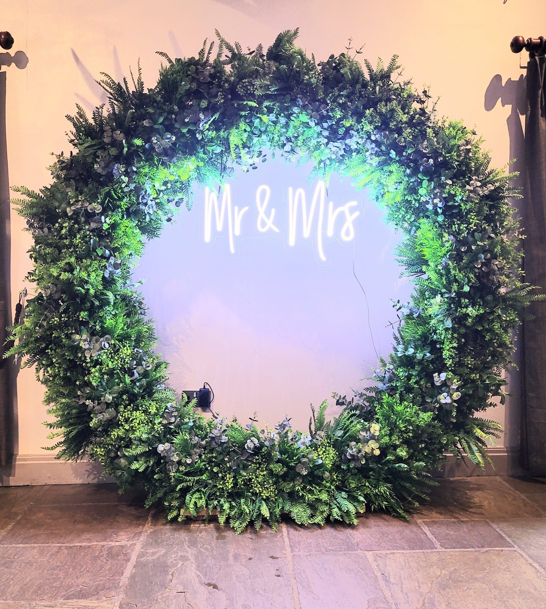 6ft round foliage moongate hoop with mr and mrs neon sign attached to create a backdrop.