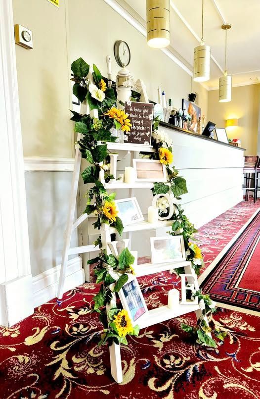 Memorial ladders with sunflower garland, candles and photoframes
